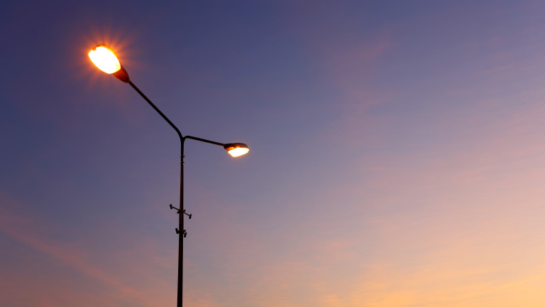 Street light illuminated sunset